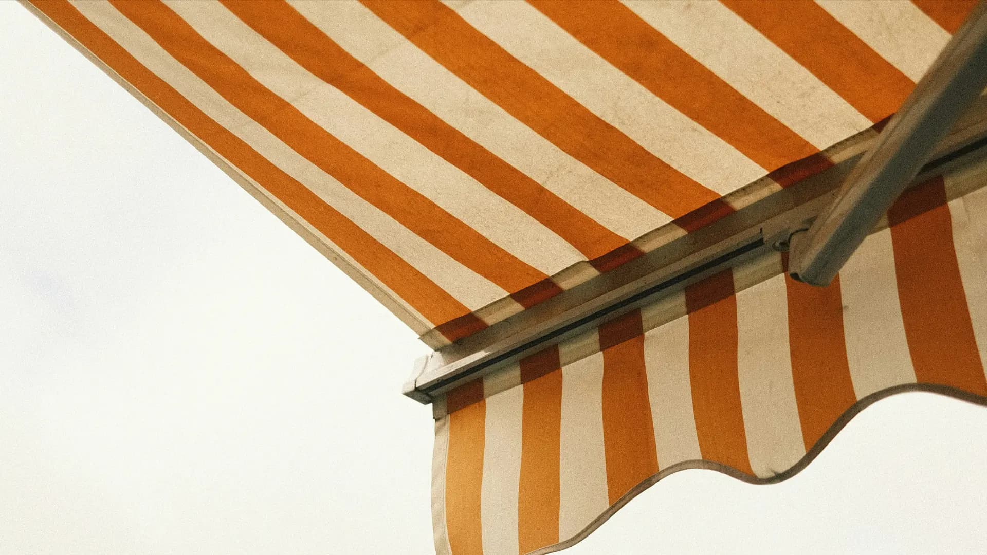 Store banne à rayures orange et blanches vu d'en dessous